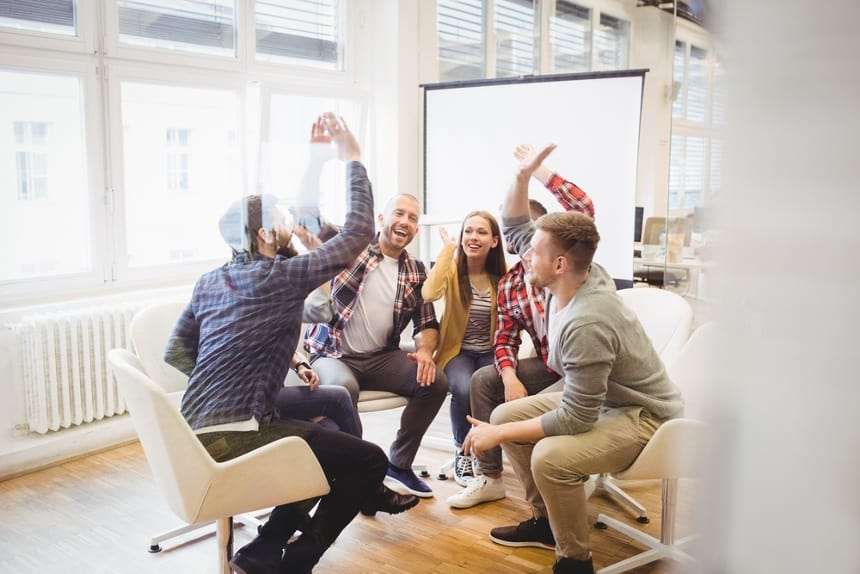 Excited creative business people giving high-five in meeting room at creative office Excited creative business people giving high five in meeting room at creative office
