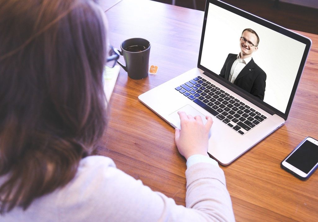 A woman in a videoconference with a man.